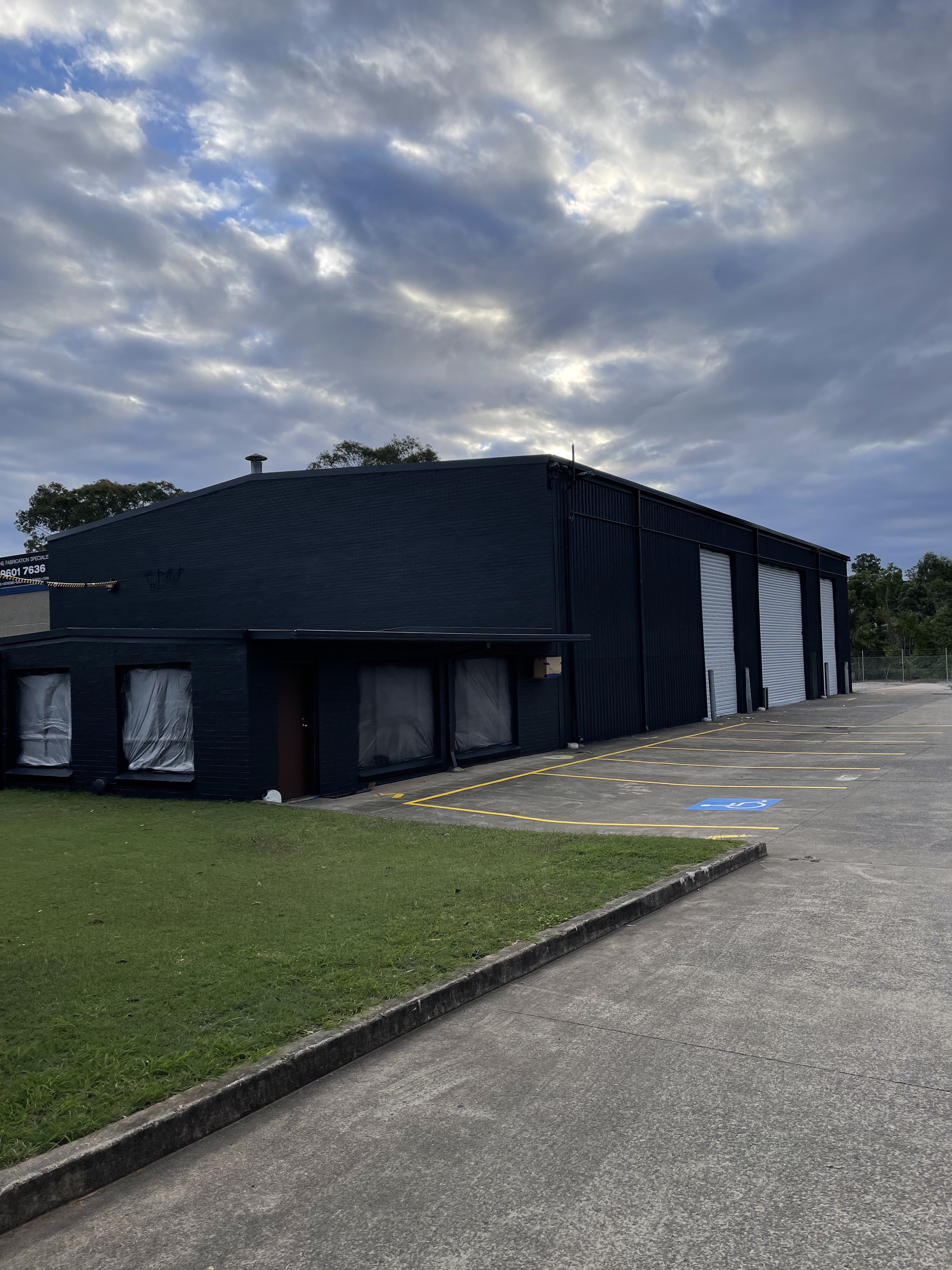 Commercial warehouse repainted dark with new roller doors