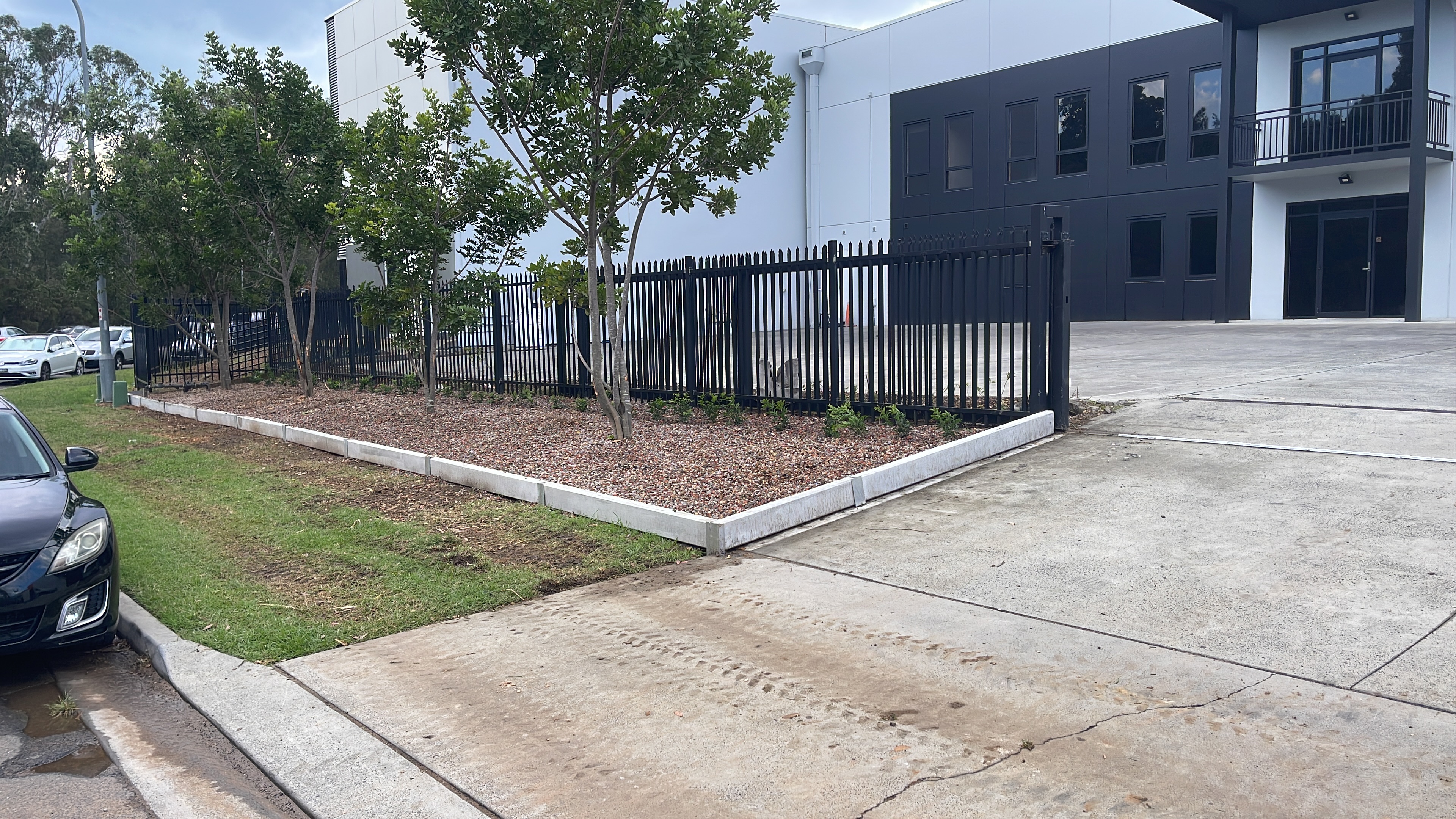 Completed garden bed with trees and mulch along fence line