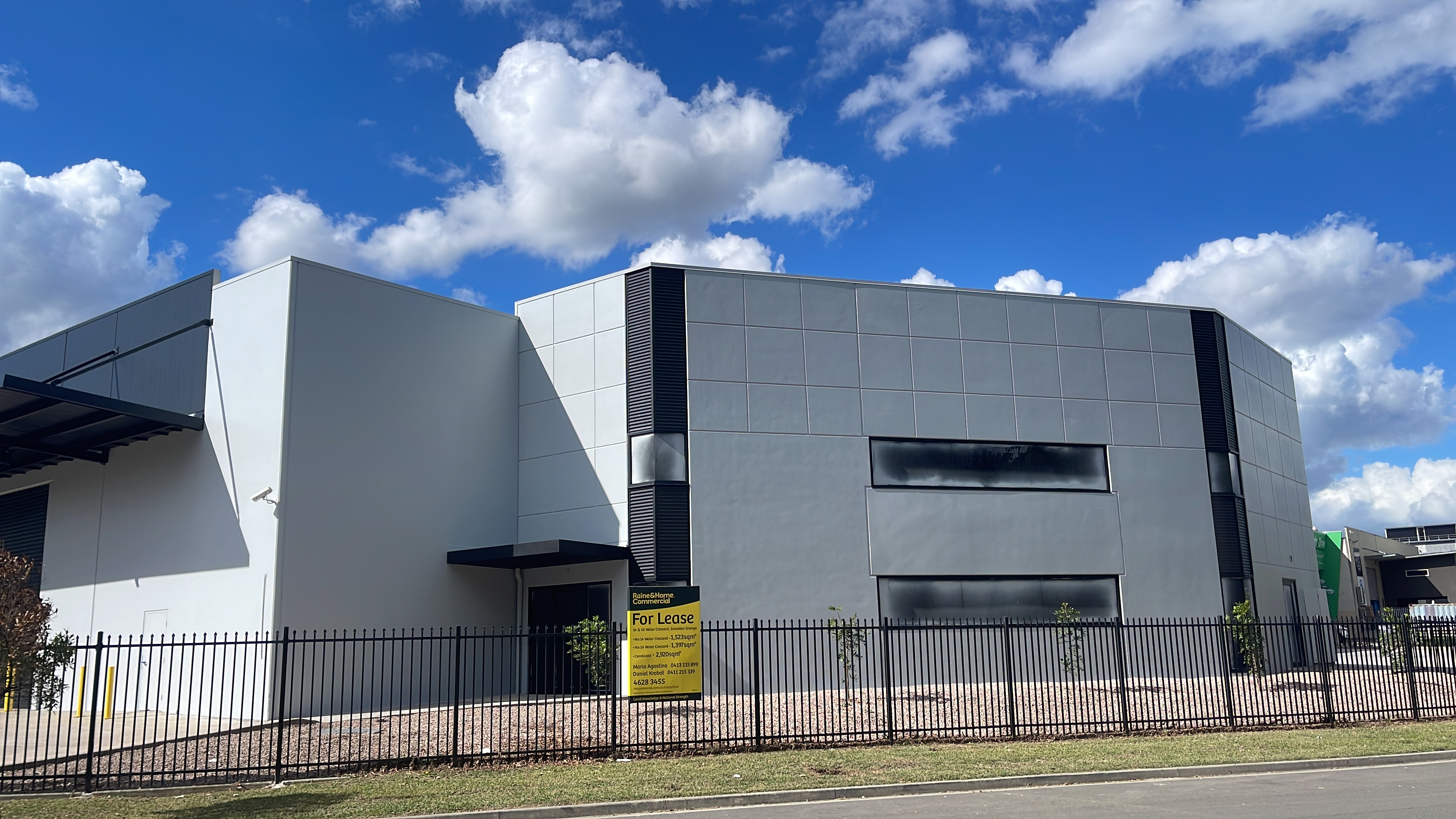 Completed commercial building with black steel canopy, street view